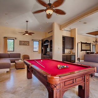 You'll love gathering here! Your spacious living area features a stunning pool table for friendly competition, plus cozy seating zones and stylish ceiling fans overhead. Natural light pours through arched windows, creating the perfect ambiance for your vac