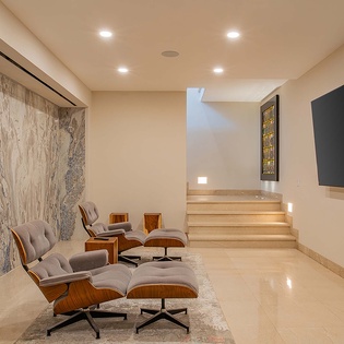 Sink into iconic mid-century lounge chairs in your private media room, where stunning marble walls and a massive screen create the perfect escape for movie nights.
