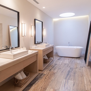 En suite bathroom with bath tub and double sink