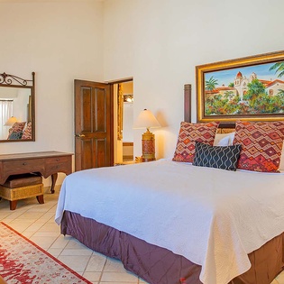 Sink into crisp linens and vibrant decor in your private bedroom, where warm Spanish-inspired art and cozy lighting invite total relaxation.