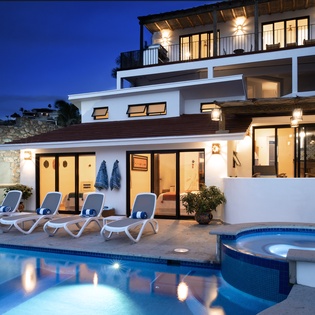 Modern villa with pool and hot tub creates perfect evening ambiance for relaxation under the stars.