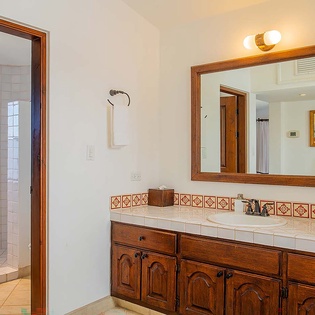 Refresh in your spacious bathroom with handcrafted tile accents, warm wood details, and a generous walk-in shower.
