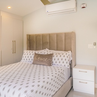 Sink into your plush bed with a welcoming 'home' pillow after exploring the coast—your sea view awaits just steps away.