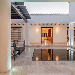 A stunning inner courtyard where contemporary design meets serene ambiance. Gather around the elegant seating area or wander through the open-air spaces that connect your living areas, all beautifully lit for evening relaxation.