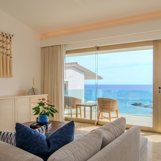 Unwind in your bright living space with stunning sea views just steps from your private balcony overlooking pristine waters.