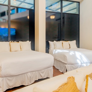 Sleep peacefully in your modern bedroom with floor-to-ceiling windows and crisp white linens.