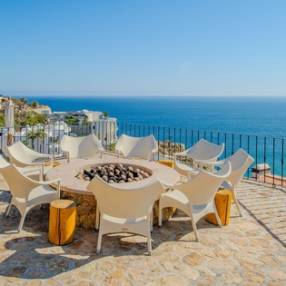 Gather around your private fire pit on this stunning sea-view terrace, where cozy evenings meet endless ocean horizons.