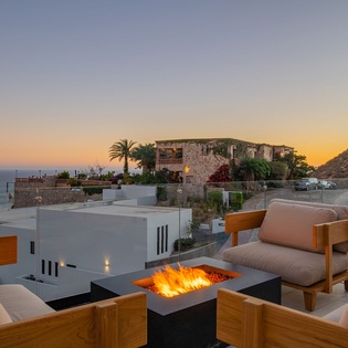 Gather around the warm fire pit as sunset paints the sky, with stunning sea views stretching beyond.