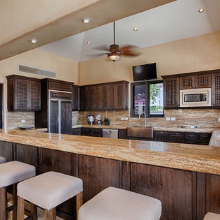 Picture yourself preparing meals in this expansive kitchen with rich wood cabinetry, granite countertops, and modern appliances. The large island offers ample space for cooking and gathering with friends.
