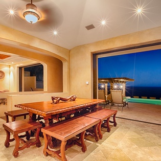 Gather for unforgettable meals at this stunning indoor-outdoor dining space, framed by ocean views and your own glowing pool—a perfect spot for relaxing evenings together.