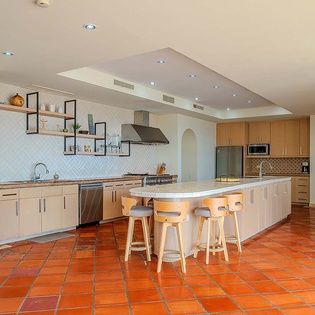 This spacious kitchen features modern appliances, ample counter space, and a large island with seating—perfect for cooking together or enjoying casual meals during your stay.