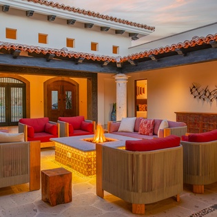 Gather around your private fire table in this stunning courtyard, where warm flames dance as you relax on plush seating.