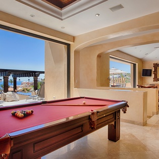 A stunning billiards room frames ocean views through expansive archways. Challenge your group to a game while soaking in coastal breezes and endless blue horizons.