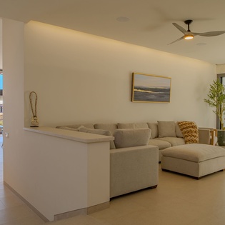 Unwind in your spacious living area with plush sectional seating and contemporary design, where large windows frame tropical views.