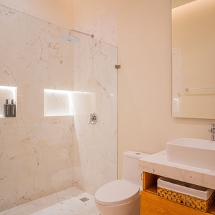 Step into your spa-like bathroom featuring elegant marble walls, a rainfall shower, and warm wood accents that create the perfect retreat.