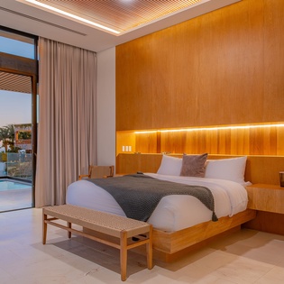 Unwind in your stunning bedroom where warm wood tones and soft lighting create the perfect sanctuary for restful nights.