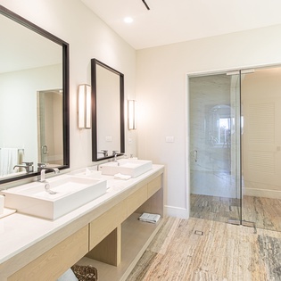 En sutie bathroom with double sink with walk in shower