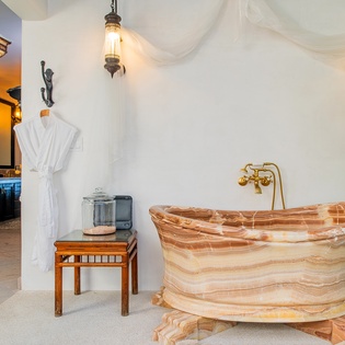 En suite bathroom with footed bathtub and bath robes