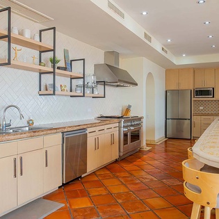 Your spacious kitchen awaits with warm terracotta tile floors, stylish open shelving, and all the modern appliances you need. Cook up a feast on the gas range or gather around the island—your home away from home.