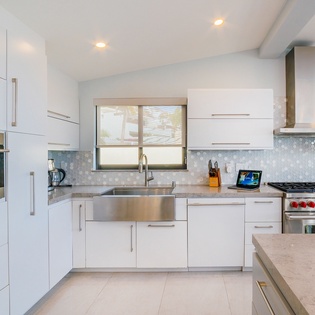 Your sleek modern kitchen awaits with professional-grade appliances, pristine white cabinetry, and elegant marble countertops perfect for culinary adventures.