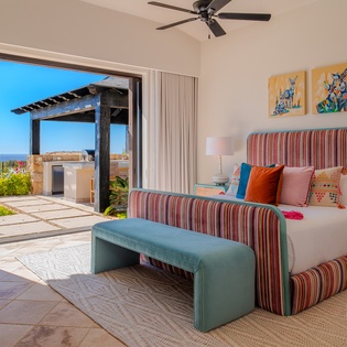 Wake up to stunning views from your private terrace through floor-to-ceiling windows. Colorful textiles and comfortable seating create a vibrant, relaxing retreat.