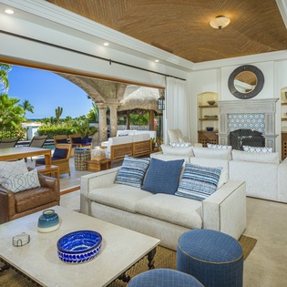 Sink into plush seating where tropical breezes drift through open walls, creating your perfect indoor-outdoor sanctuary.
