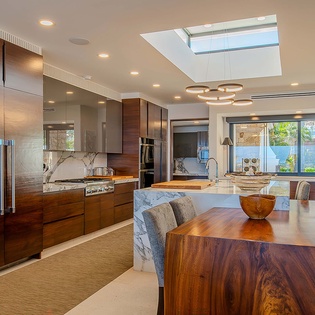 Your gourmet kitchen features sleek marble counters, rich wood cabinetry, and a skylight that fills the space with natural light—perfect for preparing memorable meals.