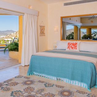 Wake up to stunning mountain views in your bright, airy bedroom with direct terrace access and coastal-inspired turquoise bedding.