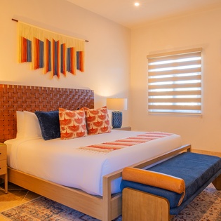 Drift off surrounded by vibrant Mexican artwork and handcrafted details in your beautifully appointed bedroom sanctuary.