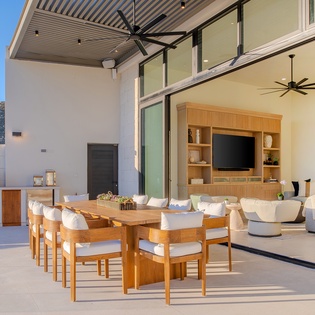 Unwind in your seamless indoor-outdoor living space where warm wood dining flows into plush lounge seating, complete with mountain views and modern amenities.