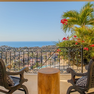 Relax on your private terrace with stunning ocean views, tropical palms, and comfortable seating—your perfect escape awaits.