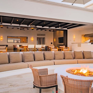 Gather around the fire pit or unwind on the expansive terrace seating, where indoor-outdoor living blends seamlessly under warm ambient lighting, perfect for your evening relaxation.