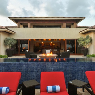 Poolside view with lounge chairs and fire pit