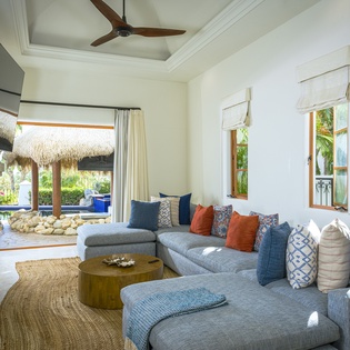 Sink into the plush sectional sofa while enjoying tropical breezes from your private outdoor space with stunning thatched-roof views.