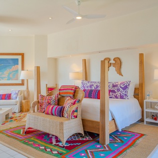 Unwind in your vibrant suite where tropical colors and natural textures create a perfect paradise retreat.