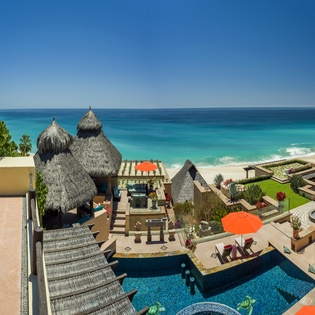 Stunning beachfront paradise with pristine turquoise waters, private pool, and tropical palapa structures overlooking endless ocean views.