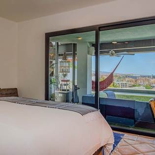 Step onto your private balcony and unwind in a cozy hammock, where vibrant city views and ocean breezes create the perfect retreat after a day of adventure.