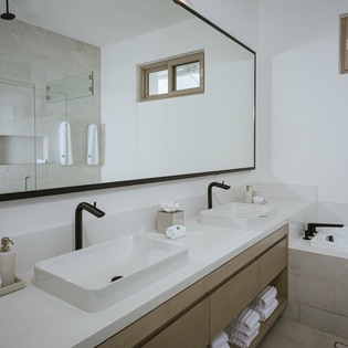 En suite bathroom with double sink and bath tub