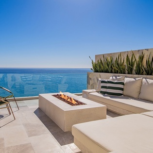 Sunny patio with outdoor seating and fireplace