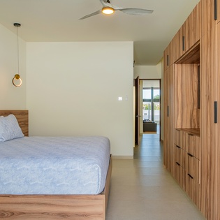Your serene bedroom features crisp linens, warm wood tones, and built-in storage for your belongings.