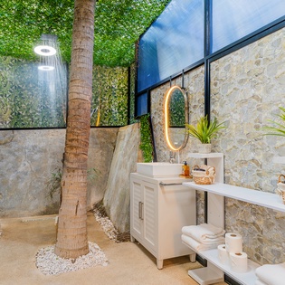 Step into your private tropical oasis—an open-air bathroom where you'll shower under the sky surrounded by lush greenery.