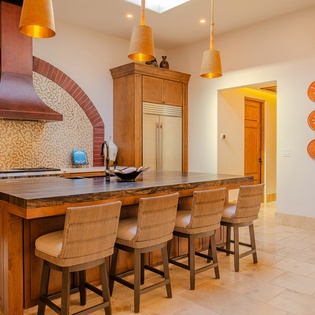 Your spacious kitchen island awaits with warm wood tones and vibrant Mexican tiles creating the perfect space for cooking.
