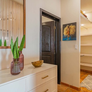 Bright and welcoming interior with thoughtful decor touches—warm wood accents, colorful artwork, and fresh greenery create a cozy, personal retreat where you'll feel right at home.