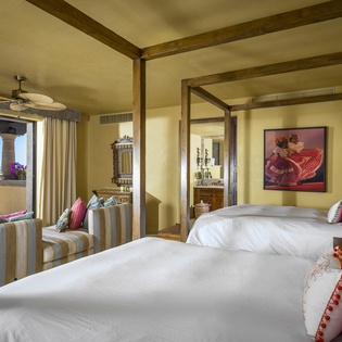 Wake up to stunning ocean views from your plush twin beds, where vibrant Mexican décor meets luxury comfort in this beachfront sanctuary.