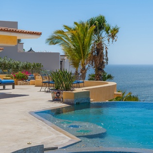 Dive into your private infinity pool where crystal-clear waters meet endless ocean views, surrounded by swaying palms and sunshine.