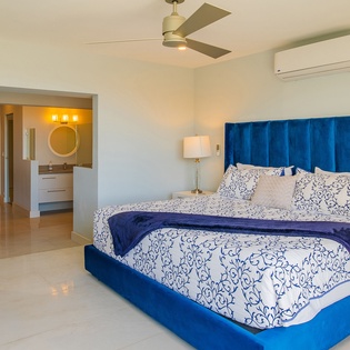 Drift into peaceful dreams in your elegant bedroom, where luxurious blue velvet embraces you and gentle breezes whisper from above.