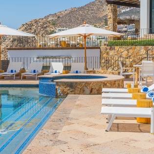 Unwind by your private pool with mountain views, lounging on comfortable sunbeds under umbrellas in this stunning hillside retreat.