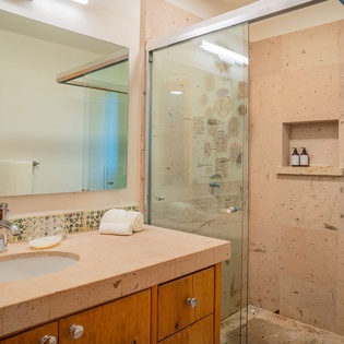 Step into your spa-like bathroom with natural stone finishes, glass-enclosed shower, and thoughtful amenities for a refreshing retreat.