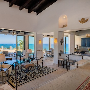 Spacious living area with ocean views and patio access