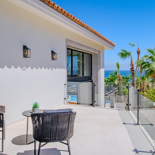 Relax on your private terrace with stunning sea views, surrounded by tropical palms and modern comfort.